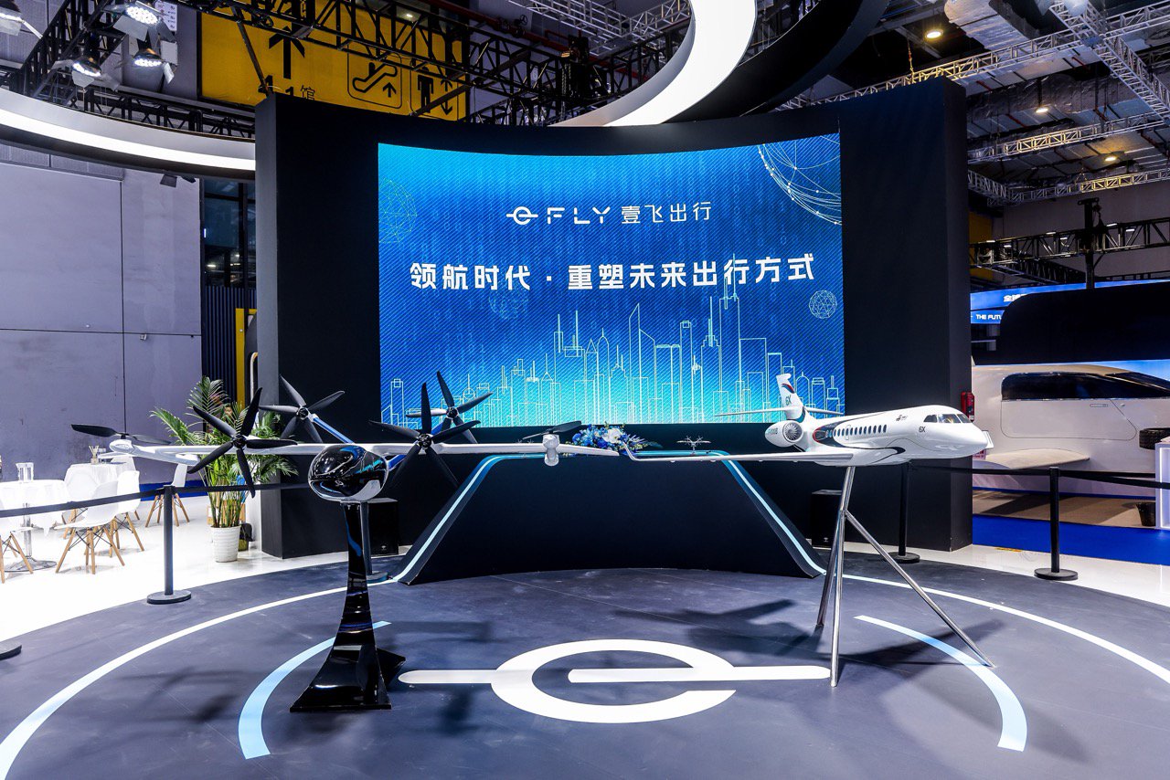 华龙航空展台。左侧为沃飞AE200载人eVTOL，右侧为达索猎鹰6X远程宽体公务机。（来源：华龙航空）